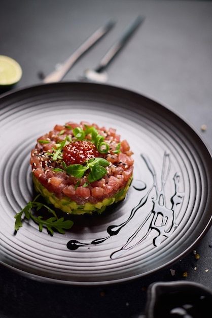 Tartare di tonno e avocado su un piatto di ceramica scura