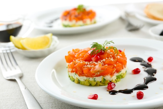 Tartaro fresco con avocado di salmone e salsa di soia su piastra bianca da vicino