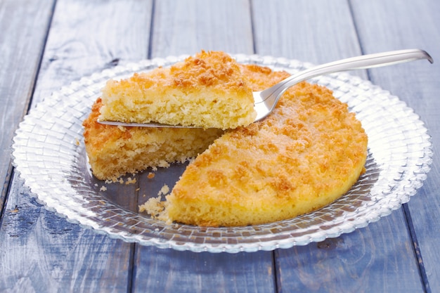 Tarte della noce di cocco sul piatto sulla tavola blu