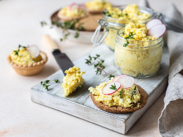 Tartellette con patè di uova o insalata e ravanelli e timo Salsa d'uovo in vasetto di vetro