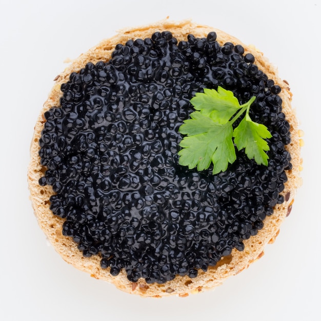 Tartine con caviale di storione nero e spezie isolate su sfondo bianco.