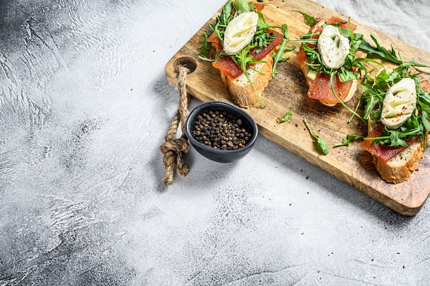 Tartine su una baguette con formaggio di capra, rucola e marmellata di pere. Vista dall'alto. Copia spazio