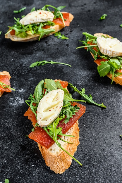 Tartine su una baguette con formaggio di capra, rucola e marmellata di pere. Vista dall'alto