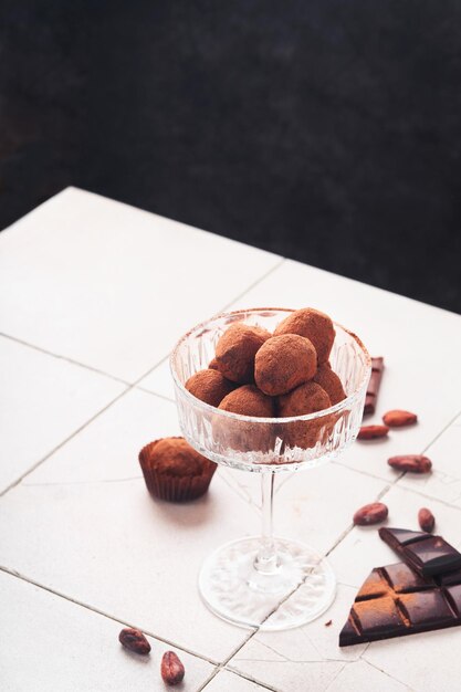 Tartufi al cioccolato Tartufi al cioccolato fatti in casa con cacao in polvere su vetro su sfondo vecchio tavolo piastrellato incrinato Gustose caramelle al tartufo al cioccolato dolce Concetto di San Valentino e festa della mamma