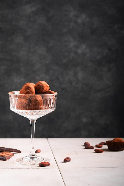 Tartufi al cioccolato Tartufi al cioccolato fatti in casa con cacao in polvere su vetro su sfondo vecchio tavolo piastrellato incrinato Gustose caramelle al tartufo al cioccolato dolce Concetto di San Valentino e festa della mamma