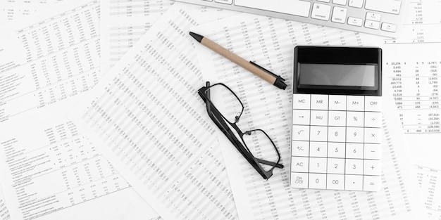 Tastiera calcolatrice e occhiali che si trovano sul rendiconto finanziario Concetto finanziario