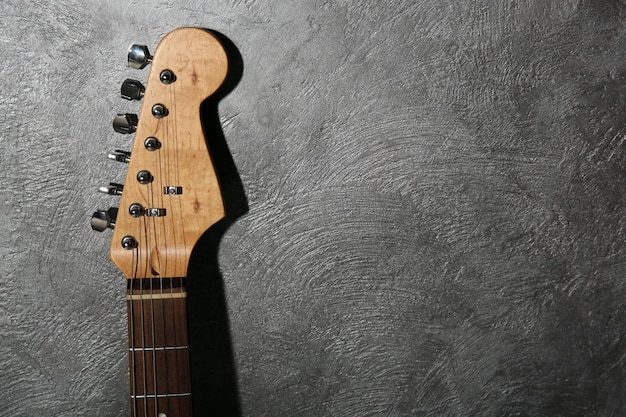 Tastiera della chitarra su sfondo grigio da vicino