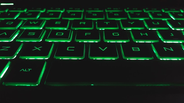 Tastiera per laptop di tipo Qwerty con luce verde Sfondo di tecnologia moderna