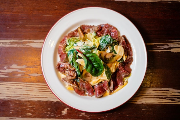 Tataki di manzo con insalata di banane Cucina orientale panasiatica su tavola di legno