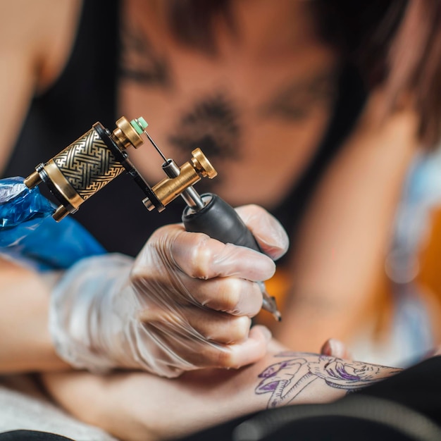 Tattoo Machine Close Up Artista del tatuaggio che crea tatuaggio sul braccio di un uomo