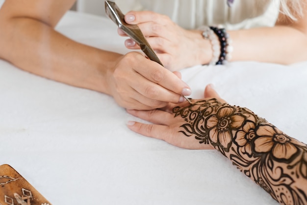 Tatuaggio all'henné su mani di donna artista disegno arabo mehndi