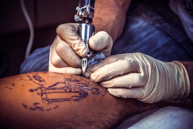 Tatuatore al lavoro, primo piano.