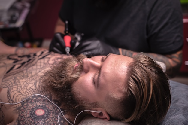 Tatuatore professionista dimostra il processo per ottenere un tatuaggio nel suo salone.