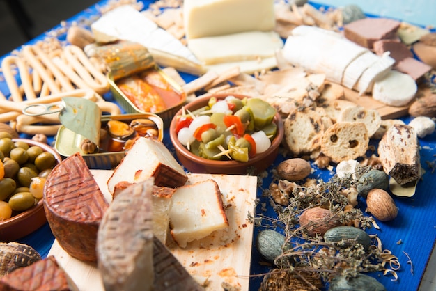 tavola apparecchiata con aperitivo composto da cibi diversi formaggi e lattine di sottaceti