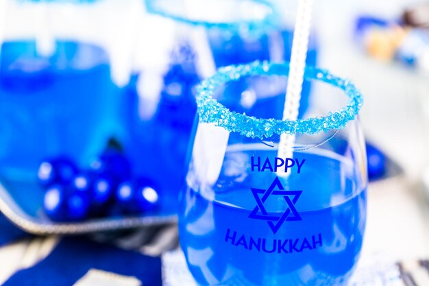 Tavola apparecchiata con cocktail e cioccolatini per celebrare Hanukkah.