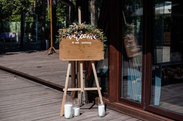 Tavola che si trova sull'erba con l'iscrizione del matrimonio Welcome Mockup per l'annuncio