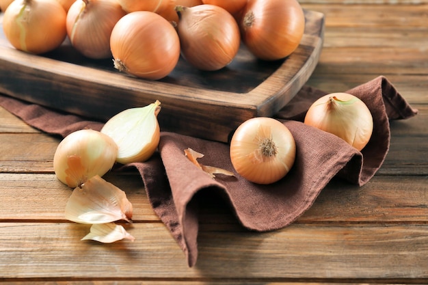 Tavola con cipolla gialla cruda fresca su fondo di legno