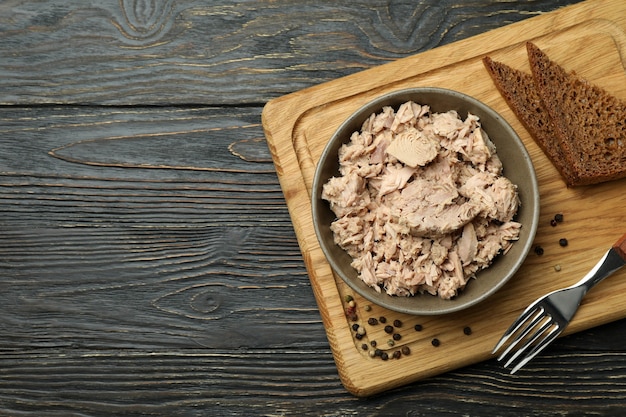 Tavola con piatto di tonno in scatola su fondo di legno