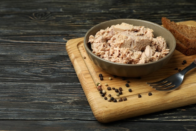 Tavola con piatto di tonno in scatola su fondo in legno