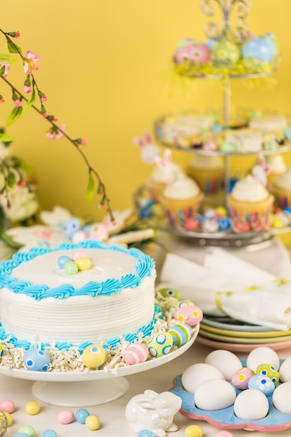 Tavola da dessert con torta e cupcakes per il brunch di Pasqua.