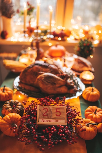 Tavola da pranzo per le vacanze del Ringraziamento con zucche e calendario in legno nella decorazione autunnale