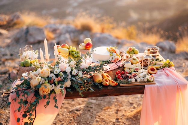 Tavola decorata per una festa di matrimonio con un bouquet di rose bianche, frutta e torta