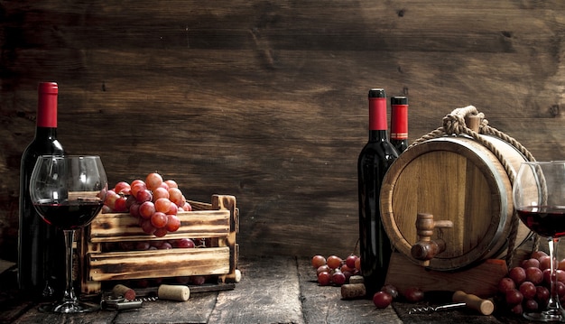 Tavola dei vini. Una botte con vino rosso e uva fresca. Su un tavolo di legno.