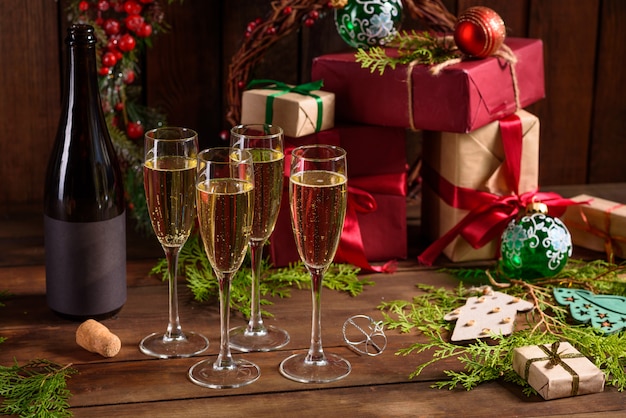 Tavola delle vacanze di Natale con bicchieri e una bottiglia di vino di champagne