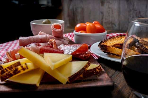 Tavola di formaggi e salumi, pomodorini, olive. Vista normale.