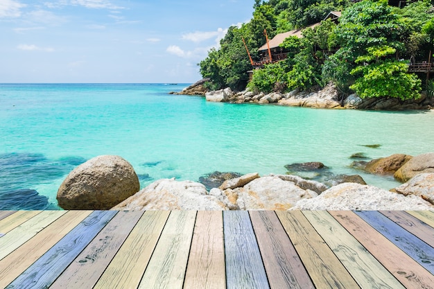 Tavola di legno colorata con mare cristallino e resort