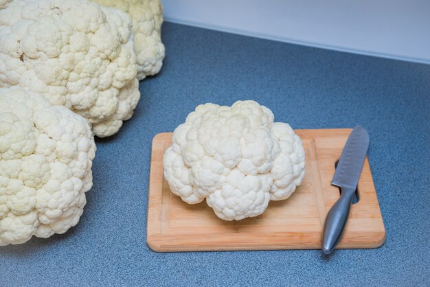 Tavola di legno, coltello e cavolfiore sul tavolo della cucina