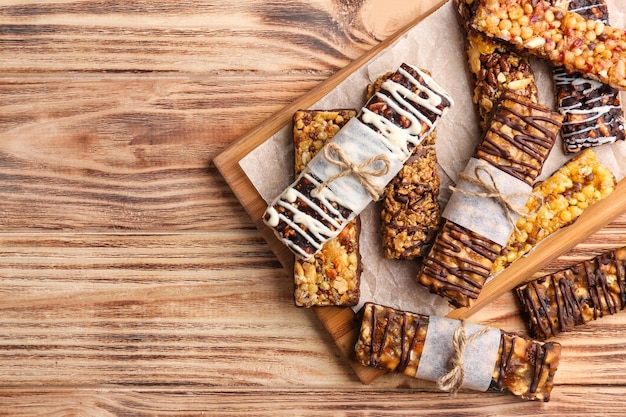 Tavola di legno con barrette energetiche di cereali sul tavolo