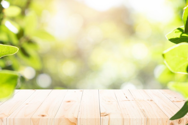 Tavola di legno con il fondo della sfuocatura di bokeh verde.