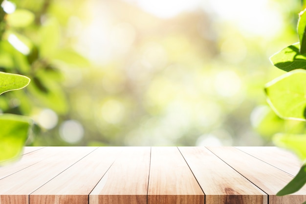 Tavola di legno con il fondo della sfuocatura di bokeh verde.