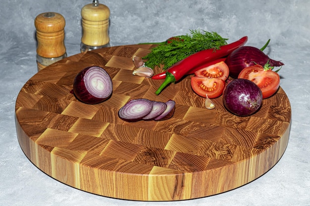 Tavola di legno per il taglio di prodotti fatti a mano con verdure tritate su sfondo chiaro