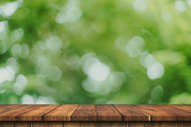 Tavola di legno vuota e sfocatura verde del bokeh con montaggio dell'esposizione dello spazio della copia per prodotto.