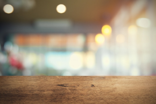 Tavola di legno vuota sul fondo della caffetteria della sfuocatura