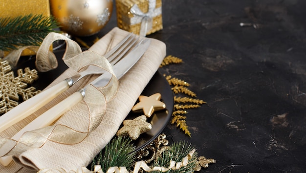 Tavola di Natale dorata e nera con decorazioni natalizie
