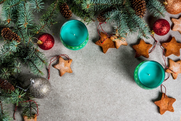 Tavola di Natale, per biglietto di auguri. Biscotti della decorazione di Natale, delle candele, dell'albero di abete e del pan di zenzero sulla tavola di pietra grigia. Vista dall'alto, .