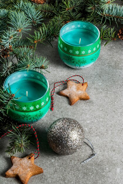 Tavola di Natale, per biglietto di auguri. Biscotti della decorazione di Natale, delle candele, dell'albero di abete e del pan di zenzero sulla tavola di pietra grigia. .