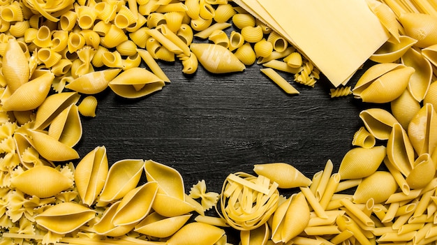 Tavola di pasta. Asciugare la pasta. Sul tavolo di legno nero. Spazio libero per il testo. Vista dall'alto