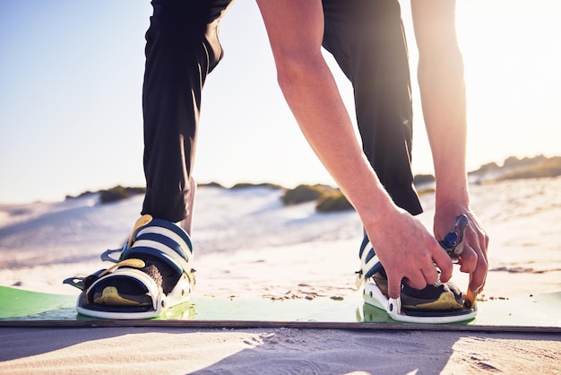 Tavola di sabbia e scarpe da uomo pronte per il surf nel deserto sport estremi e hobby d'azione nella natura Avventura di libertà e piedi di atleta all'aperto per esercizi di fitness e allenamento di dune surfer