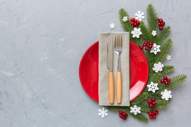 Tavola natalizia con decorazioni natalizie e piatti, kine, forchetta e cucchiaio. Priorità bassa di festa di Natale. Vista dall'alto con copia spazio