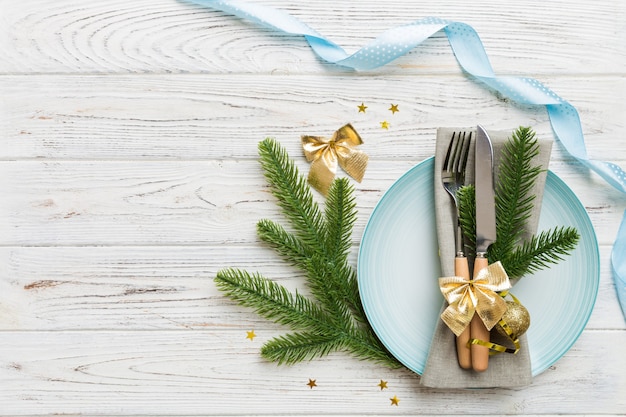 Tavola natalizia con decorazioni natalizie e piatti, kine, forchetta e cucchiaio. Priorità bassa di festa di Natale. Vista dall'alto con copia spazio