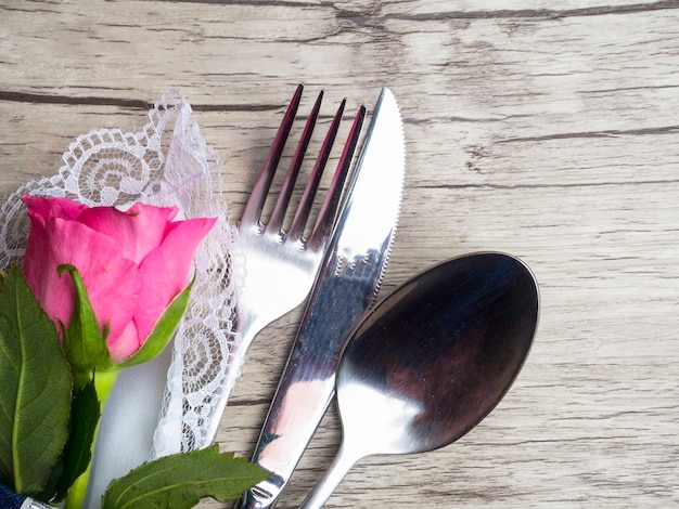 Tavola romantica di San Valentino con posate rosa rosa su sfondo di legno bianco Piatto vuoto Layout di design mockup per il tuo testo Amore concetto di San Valentino Copia spazio Vista dall'alto Disposizione piatta