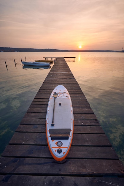 Tavola SUP su un molo sul lago al tramonto a Varna Bulgaria