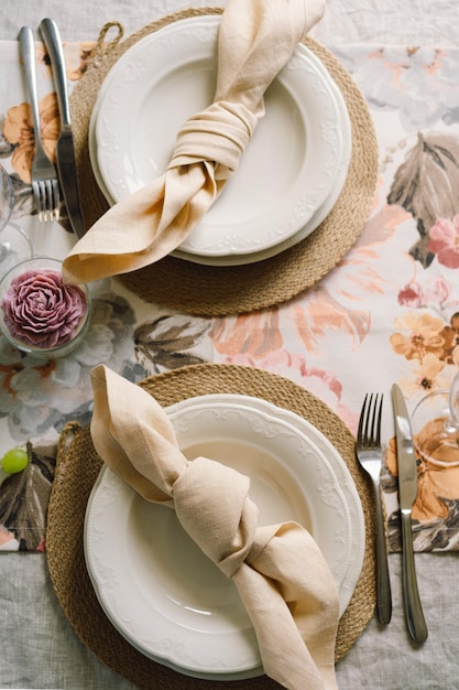 Tavola vintage con tovaglioli di lino e decorazioni floreali Primo piano Accogliente pasto tranquillo al mattino sotto il sole