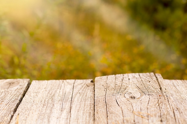 Tavole di legno su uno sfondo autunnale sfocato