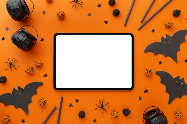 Tavoletta digitale con decorazioni di Halloween su sfondo nero arancione