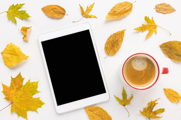 Tavoletta digitale mock up tazza di caffè espresso con crema e foglie gialle su sfondo bianco autunno